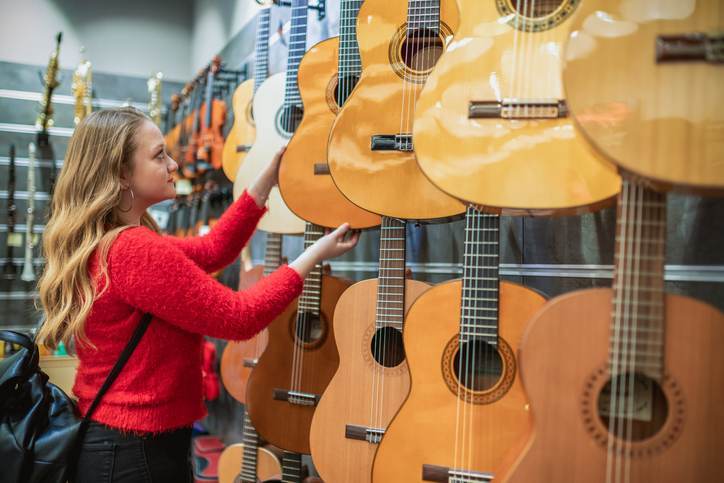 Girl choosing acoustic guitar