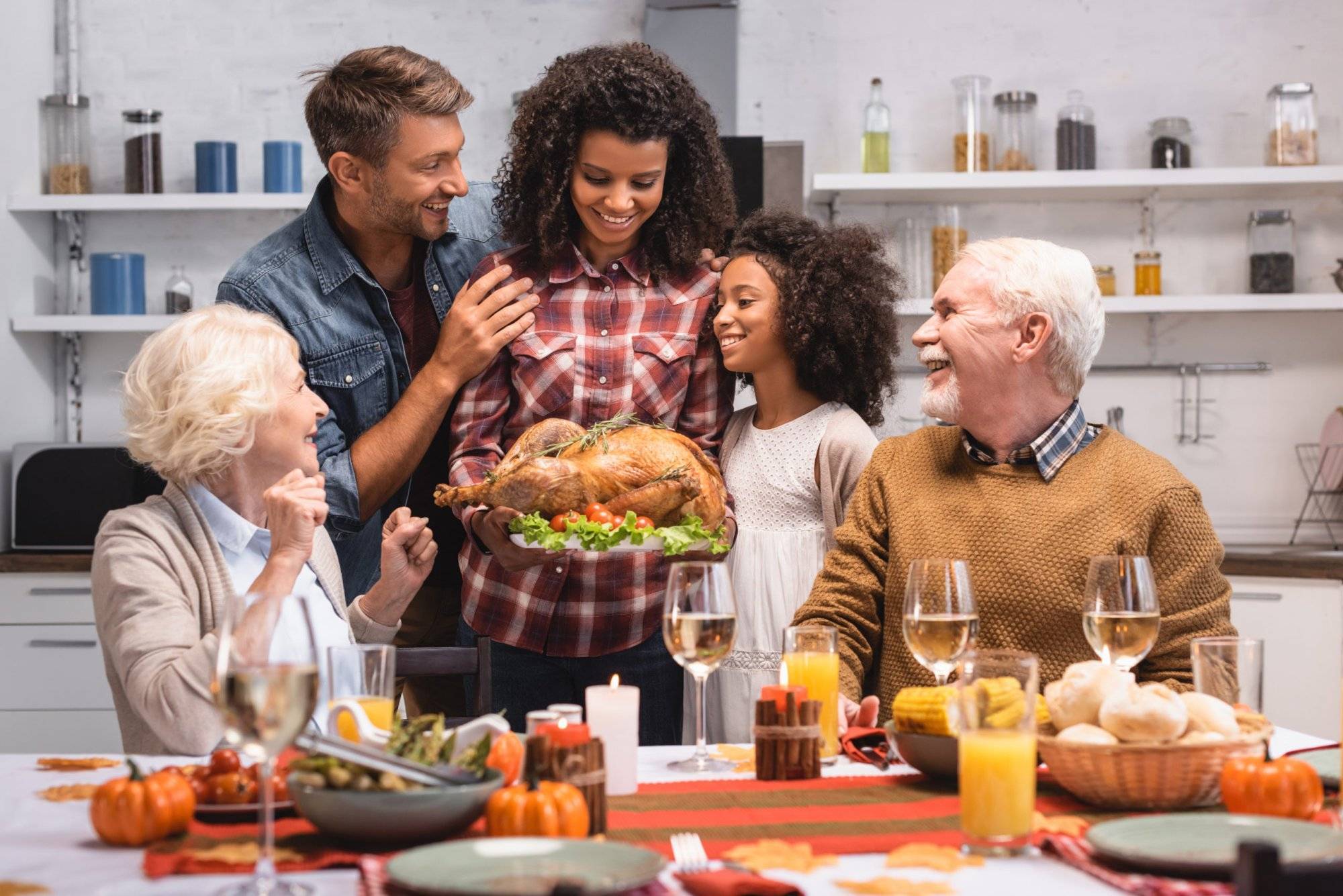 Selective focus of african american woman holding turkey near family during thanksgiving celebration